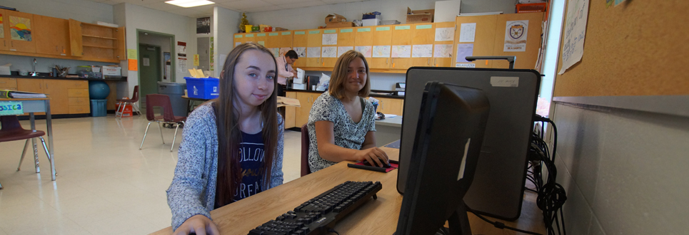 Two Grade 8 students sitting at computers.